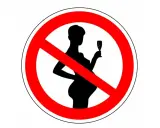 Verbotsschild: Silhouette einer schwangeren Frau mit Sektglas, durchgestrichen. Kein Alkohol in den ersten 4 Wochen der Schwangerschaft.