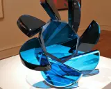 A sculpture of blue glass shards, showcasing transparency in art, with light reflecting through its facets.