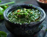 Frisches, grünes Chimichurri im Steinmörser, ein authentisches argentinisches Rezept. Perfekt für gegrilltes Fleisch.