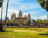 Angkor Wat, Cambodia, a majestic temple complex, bathed in sunlight. A gay couple enjoys the view, embracing the beauty of this historic site.