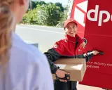 Kurierka DPD z paczką, obok czerwonego vana. Na paczce widoczny numer listu przewozowego przykład.