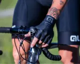 Rowerzysta w czarnych, bezpalczastych rękawiczkach, idealnych na rower, trzyma kierownicę.