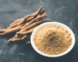 Korzeń i proszek ashwagandhy na ciemnym tle.