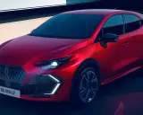 El nuevo Clio 2026, un coche rojo vibrante con diseño moderno, se presenta en un entorno urbano con luces LED llamativas.