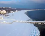 Zimowy spacer po molo w Sopocie to świetny pomysł, gdzie na ferie zimowe. Wokół biała, śnieżna przestrzeń i błękitne niebo.