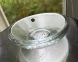 En Orrefors skål, ett tidlöst konstverk. Denna glasdesign med en grön prick och graverad text visar Orrefors skålar genom tiderna.