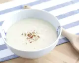 Un bol de sauce béchamel onctueuse, saupoudrée de noix de muscade râpée, prêt pour votre recette.