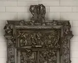 Detaljerad bronsrelief av helvetets portar, med figurer i dramatiska poser.