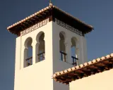 Weiße Moschee in Granada mit arabischer Kalligrafie und maurischen Bögen.