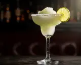 En frostig frozen margarita med saltkant och limeklyfta, perfekt för en varm dag.