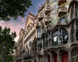Casa Batlló in Barcelona, ein Meisterwerk des Art Nouveau, mit seinen organischen Formen und bunten Mosaiken, unter einem rosafarbenen Himmel.