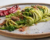 Spaghetti verdi con verdure, acciughe e peperoncino secco, un piatto tipico Basilicata che evoca sapori autentici.