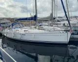 Un voilier Dufour 385 Grand Large blanc, amarré dans un port, reflète son élégance sur l'eau calme.