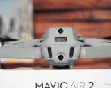 Graue Drohne Mavic Air 2 mit Kameras und Propellern. Auf dem Gehäuse ist ein Aufkleber mit der Kennung zur drohne registrieren.