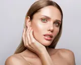 Mujer con piel radiante y labios brillantes, mostrando los pasos para maquillarse con un look natural y elegante.