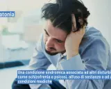 Uomo con mano tra i capelli, con testo "Catatonia" e la sua definizione. Il catatonia significato è una condizione sindromica.