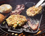 Burger-Patties und Brötchenhälften werden auf einem Grillrost zubereitet. Das Burger grillen verspricht einen köstlichen Genuss.