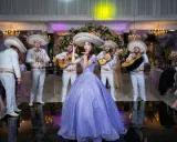 Dziewczyna w fioletowej sukni i mariachi śpiewają, tworząc atmosferę pełną radości i być może sprośnych przyśpiewek.