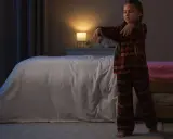 Bambina in pigiama a quadri cammina nel sonno, un esempio di sonnambulismo bambini.
