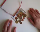 Manos sobre billetes y monedas, sugiriendo aportaciones a planes de pensiones IRPF.