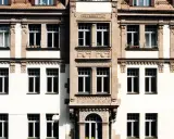 Fassade eines Altbaus mit vielen Fenstern. Hier könnte eine energetische Sanierung Beratung ansetzen, um das Gebäude fit für die Zukunft zu machen.