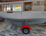 Bateau blanc sur remorque, prêt pour l'aventure. Le drapeau chypriote flotte, rappelant les eaux bleues. Un **pabouk 360** attend son prochain voyage.