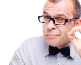 Mężczyzna w okularach i muszce pokazuje gest "OK". Okulary leżą idealnie na nosie, podkreślając jego pewność siebie.