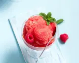 Erfrischendes Slush Eis mit Himbeeren und Minze in einem Glas, bereit zum Genießen.
