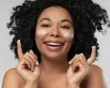 Donna sorridente con crema sul viso. La crema è non comedogeno, significa che non ostruisce i pori.