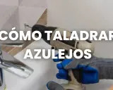 Guantes azules y grises sujetan un taladro para mostrar cómo taladrar azulejos.