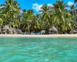 Rajska plaża San Blas z chatkami z liści palmowych i turkusową wodą.