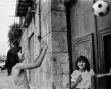 Bambine giocano a pallone in strada, un momento catturato da una fotografa famosa italiana.