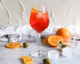 Ein Aperol Spritz mit Orangenscheibe und Eis. Orangen, Oliven und Eiswürfel deuten auf Aperol Spritz Varianten hin.