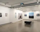 Art exhibition at blue sky gallery Portland, featuring abstract photography and a black leather ottoman.