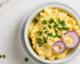 Pyszna pasta jajeczna z serem, posypana szczypiorkiem i ozdobiona krążkami czerwonej cebuli. Idealna na kanapki.