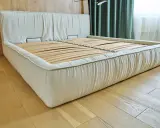 Base de cama con colchón sobre tabla de madera, lista para un descanso reparador.