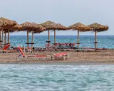 Plaża Elafonisi z rzędem słomianych parasoli i leżaków, gotowa na gości.