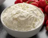 Cremiger Mascarpone in einer Schüssel, umgeben von frischen Erdbeeren. Perfekt für Tiramisu!