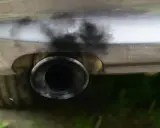 Zanieczyszczony układ wydechowy samochodu, czarny dym wydobywa się z rury. Czas na czyszczenie DPF.