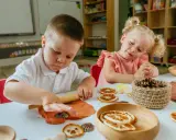 Niños de 3 a 4 años disfrutan de actividades creativas en casa, moldeando arcilla y decorando con elementos naturales.