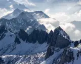 Majestatyczne Tatry Wysokie, ośnieżone szczyty i mgliste doliny tworzą zapierający dech w piersiach krajobraz.