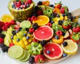 Kolorowa taca pełna owoców: ananas, maliny, borówki, truskawki, mango, kiwi, pomarańcze, grejpfruty, limonki, cytryny. Idealna na dietę owocową.