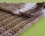 Bufanda tejida con patrones puntos reversibles a dos agujas, en tonos marrones y blanco.