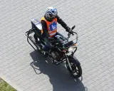Motocyklista w kamizelce z literą "L" na placu manewrowym. Czy to nauka jazdy na motorze o pojemności 250cc, by zdobyć a2 prawo jazdy?