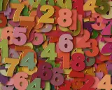 Kolorowe cyfry tworzą gęsty wzór. Wśród nich wyróżnia się liczba 2, symbolizująca rok numerologiczny 2, zachęcając do harmonii i współpracy.