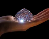 Mano che regge un enorme diamante scintillante, simbolo di eternità e amore. Il diamante significato è immenso.