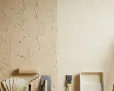 Un mur texturé et un mur lisse, avec des échelles en bois, des outils de peinture et un nuancier. Idéal pour une peinture à effet pour mur abîmé.