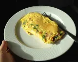 Pyszne śniadanie na redukcji: omlet z warzywami na białym talerzu, gotowy do zjedzenia.