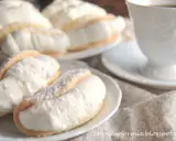Puszyste ciasteczka przełożone obfitą porcją bitej śmietany, niczym delikatny omlet z bitą śmietaną, kuszą na talerzyku.
