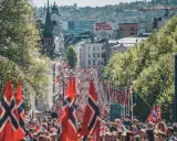 Tłum ludzi na ulicy w Oslo, z norweskimi flagami. Czy Norwegia jest w NATO? Tak, jest członkiem od 1949 roku.